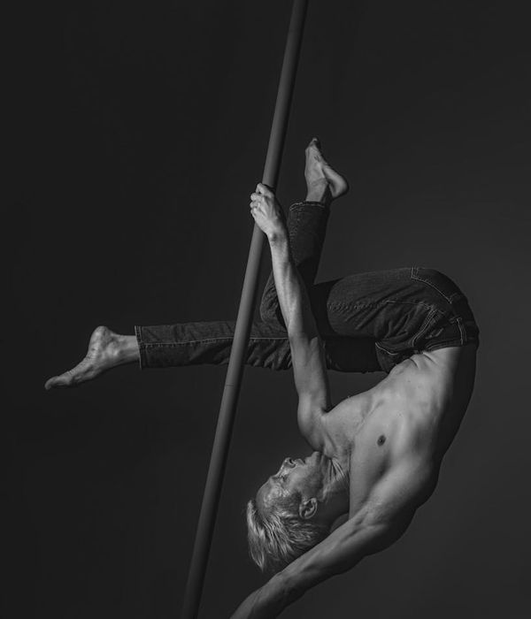 Man performing a controlled strength exercise in a modern, minimalist gym.